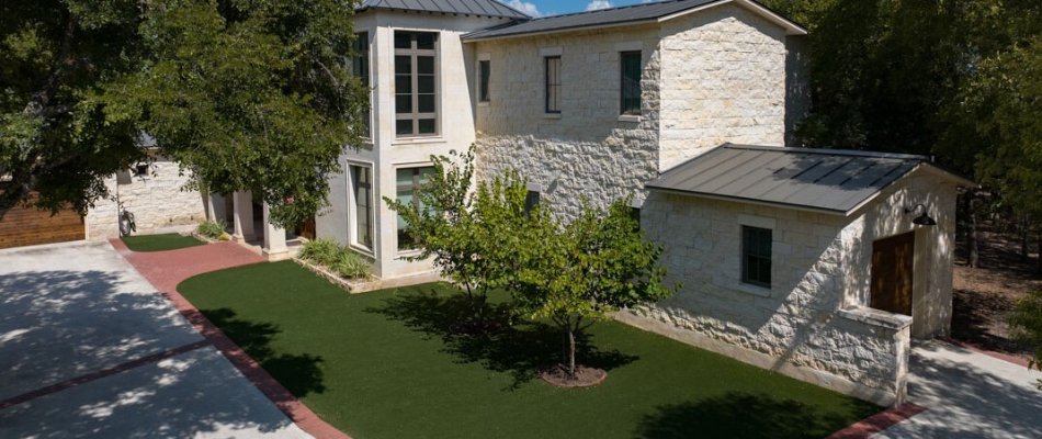 Artificial turf around two tree on a property in New Braunfels, TX.