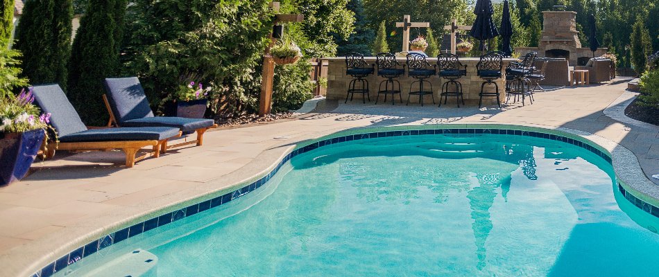 Chairs and outdoor fireplace near a swimming a pool in Overland Park, KS.