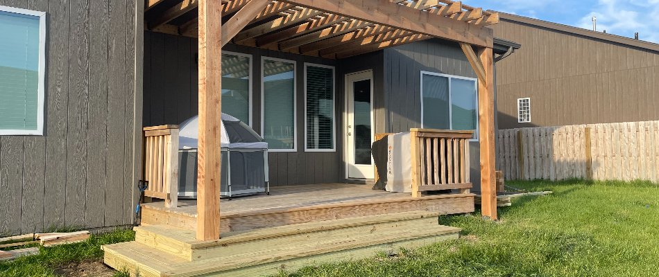 Wooden deck in Omaha, NE, with pergola.