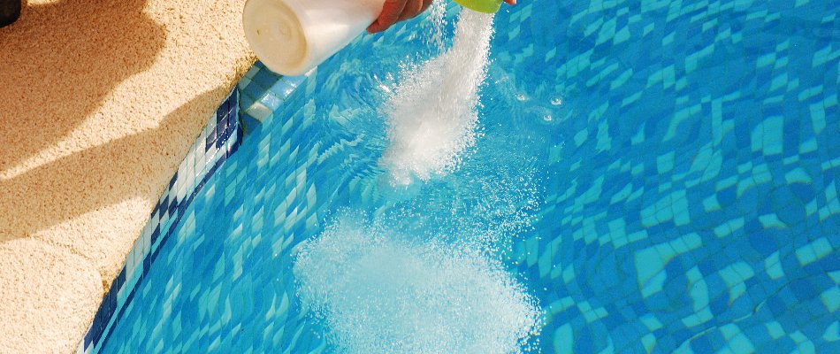 Adding chemicals to a pool in Bridgehampton, NY.