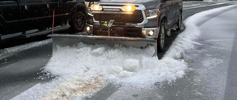 Truck with a plow clearing snow from a road in Matthews, NC.