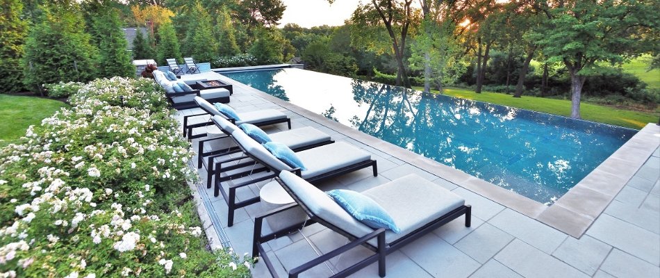 Rectangular pool in Mission Hills, KS, and lounge chairs on a deck.