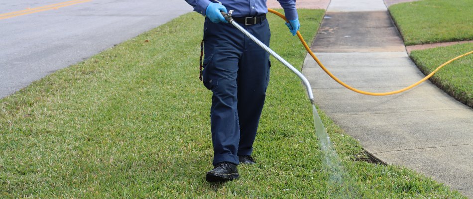 Tech applying liquid fertilizer on a lawn in Miramar, FL.