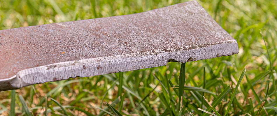 Rusty, dull mower blade over grass in Gresham, OR.