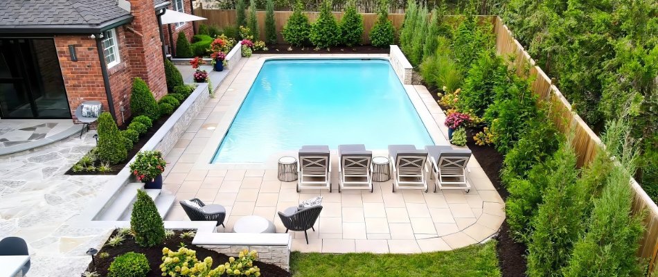Outdoor space in Overland Park, KS, with a pool surrounded by green plants.