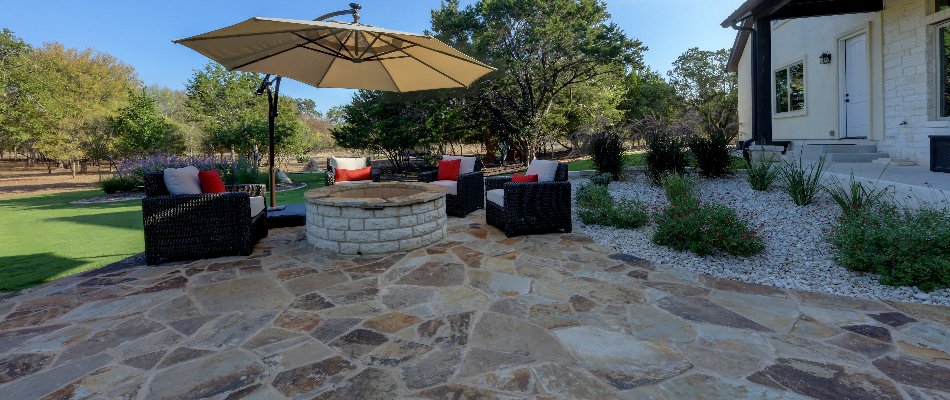 Umbrella over a fire pit with chairs on a patio in New Braunfels, TX.