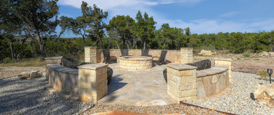Circular fire pit on a patio with seating walls in New Braunfels, TX.