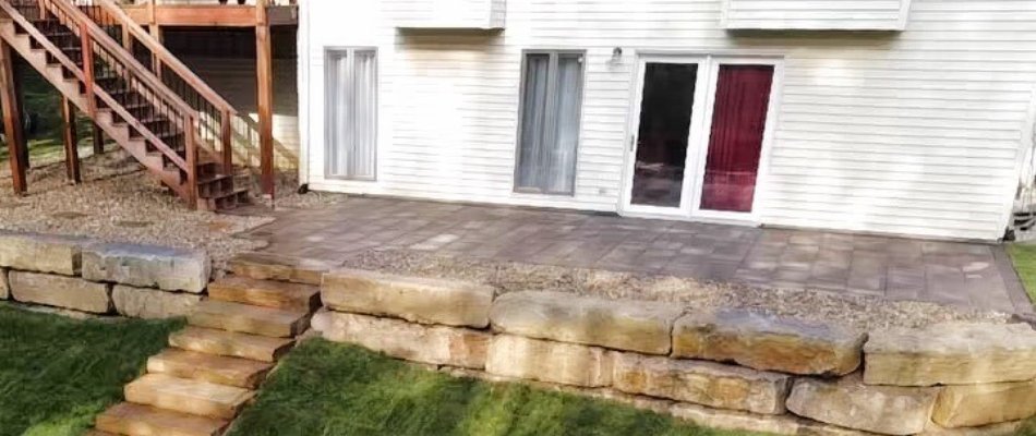 Outdoor space in Edwardsville, IL, with a patio, retaining wall, and outdoor steps.