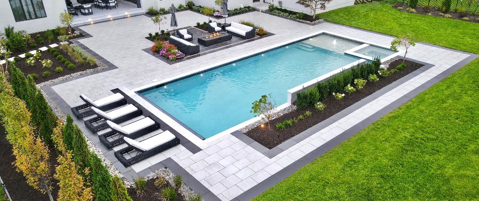 Paver patio around a pool with landscape beds in Fairway, KS.