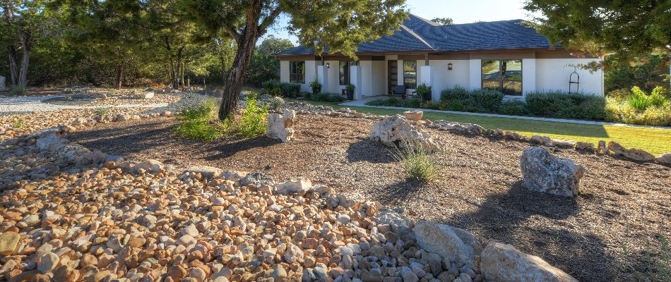 Landscape beds with plants and a dry creek bed in Spring Branch, TX.