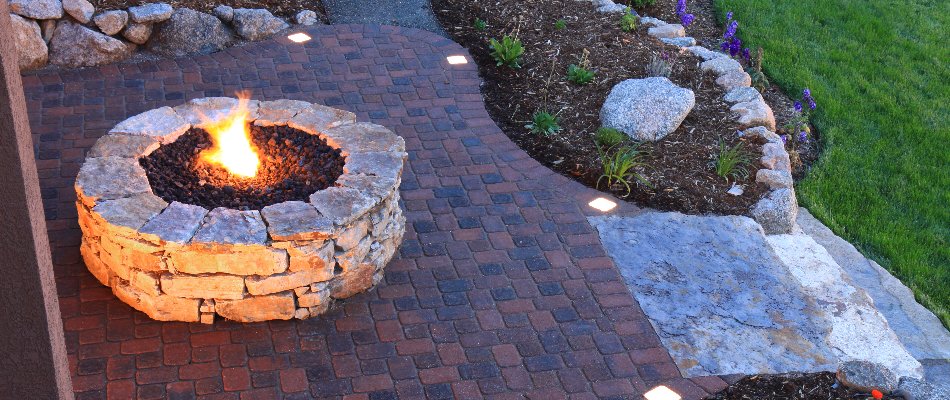 Circular fire pit with flames on a property in Matthews, NC.