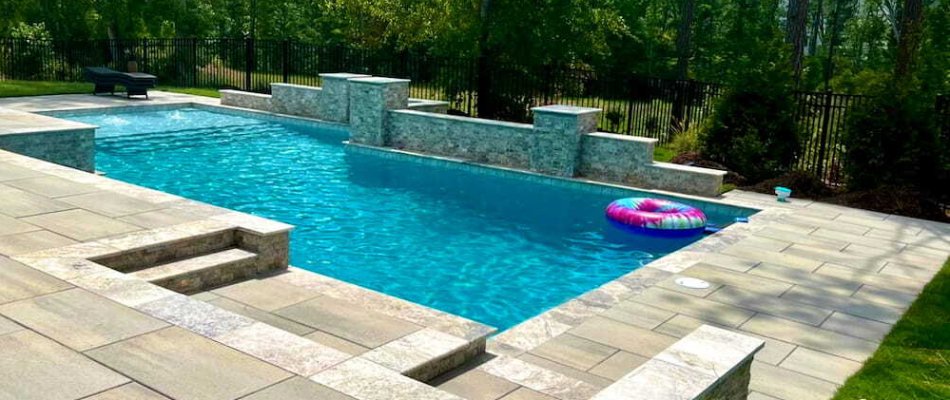 Pool in Cary, NC, with a wall and decking.