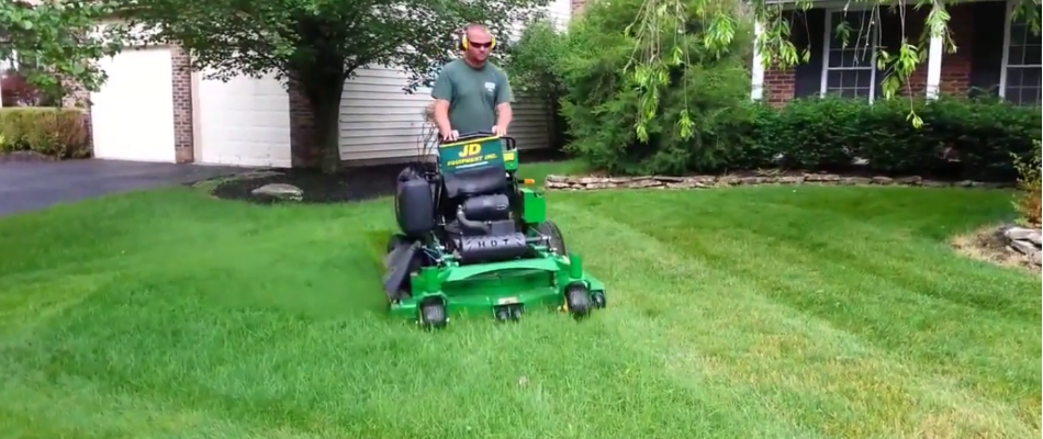 Professional mowing a lawn on a property in Delaware, OH.
