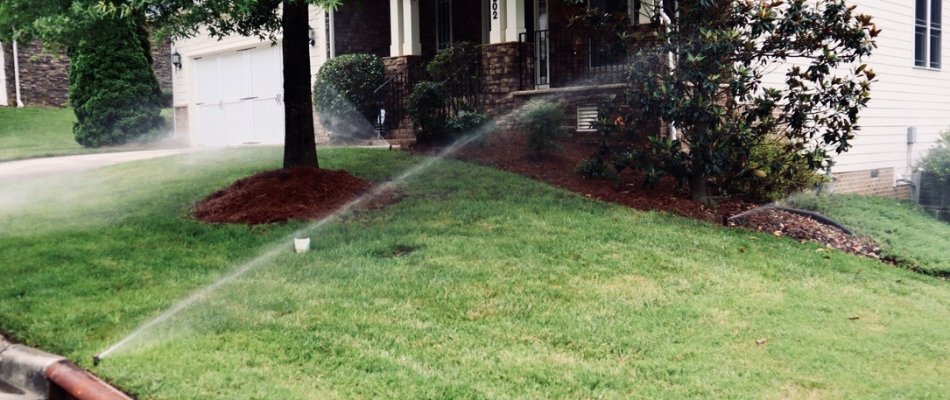 Sprinklers spraying water on a front yard in Cary, NC.