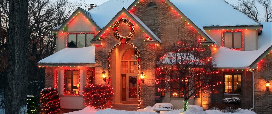 Holiday lights on a house with snow on a property in Upper Arlington, OH.
